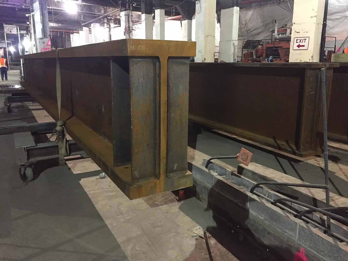 Fabricated steel beams being offloaded from a trailer at a city site